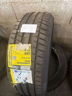 pneu posé au sol, sur lequel sont collés des autocollants, dont un sur le pneu lui-même