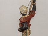 a statue of a man holding a candelier on a stand