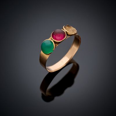 gros plan d'une bague en or avec trois pierres de couleurs différentes