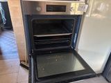 an oven that is open in the kitchen next to a refrigerator