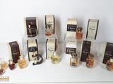 Plusieurs flacons de parfum sont alignés sur une surface blanche