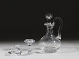 un vase en verre et deux objets en cristal posés sur une table