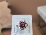 a pink ring sitting in a white box on a table