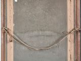 an old wooden frame with a rope hanging from it ' s side