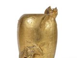 a gold vase with a bird on it on a white surface