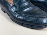 a close up of a pair of blue loafers on a white surface