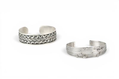 a pair of silver cuff bracelets on a white background