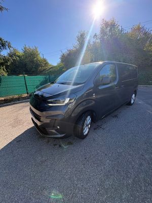 a black van parked in a parking lot with trees in the background