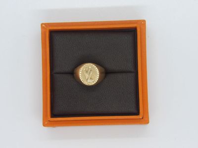 une bague en or dans un écrin noir posé sur une surface blanche