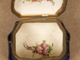 a blue and gold box with pink flowers on it