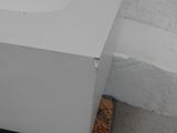 a white box sitting on top of a piece of wood