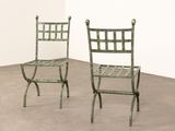 pair of green metal chairs in a room with a white wall
