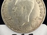une image représentant une pièce d'argent sur laquelle figure le portrait d'un homme