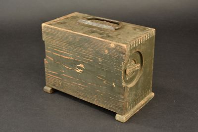 a small wooden box with a handle on a table