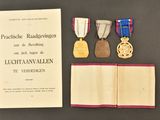 three medals and a book on a table with an open book