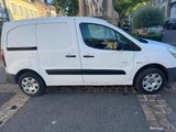 the small white van is parked on the side of the street