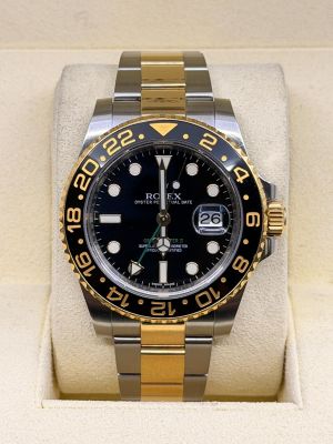 Montre Rolex avec cadran noir et lunette dorée