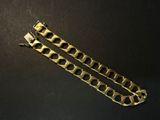 une paire de bracelets en or posés sur une surface noire