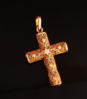 pendentif en forme de croix en or orné d'une étoile, sur fond noir