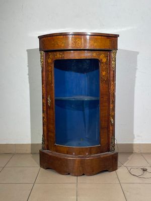 a corner cabinet with a blue glass door in the corner