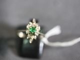 a ring with a green stone on it sitting on top of a black box