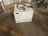 a white dishwasher sitting in the middle of a room