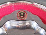 a silver plate with a horse on it on a red cloth