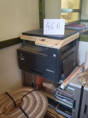 une imprimante posée sur un bureau, à côté d'un panier