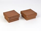 une paire de boîtes en cuir marron sur fond blanc