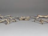 three silver figurines of animals and a dog on a table
