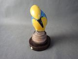 a figurine of a bird on a wooden base
