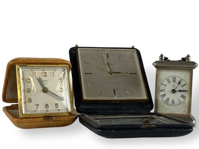 trois horloges différentes posées les unes à côté des autres sur une table