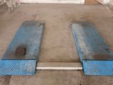 two blue ramps on the ground in a garage