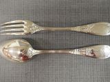 deux cuillères et une fourchette en argent sur une table