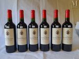 six bottles of wine are lined up on a table