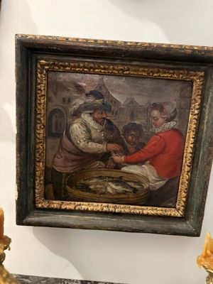 a picture of a painting hanging on a wall next to a candle