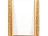 a gold framed mirror against a white wall