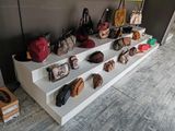 une présentation de sacs à main et de sacs à bandoulière sur une étagère blanche