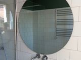 a bathroom with a sink, shower and mirror in it
