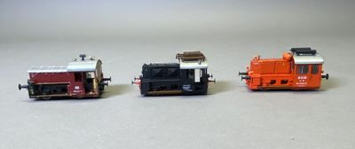 trois petits trains assis côte à côte sur une surface blanche