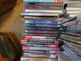 une pile de CD posée sur une table à côté d'une guitare