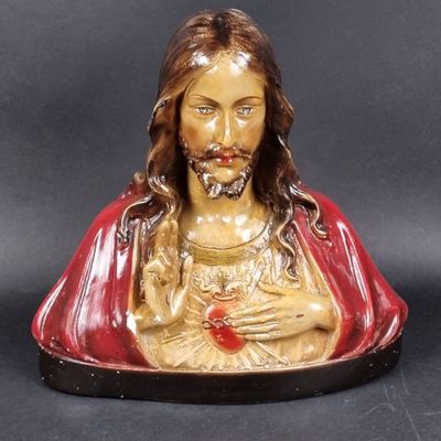 statue de Jésus tenant un cœur brisé sur fond noir