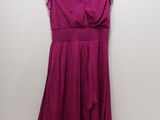 une robe violette suspendue à un cintre contre un mur