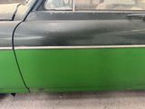 a green and black car parked on the side of the road