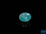 an oval faceted emerald gems on a black background
