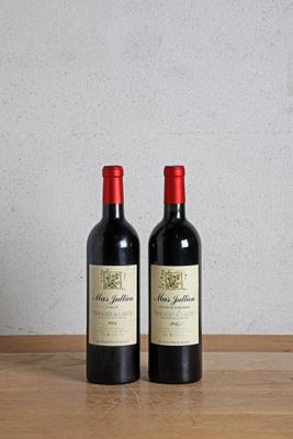two bottles of wine sitting on a wooden table next to each other
