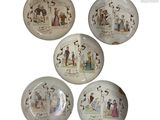 quatre assiettes sur fond blanc, ornées de motifs représentant des personnes