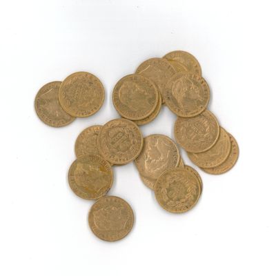 quelques pièces d'or sont éparpillées sur une surface blanche, sur fond blanc