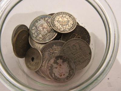 a glass jar filled with coins on a table