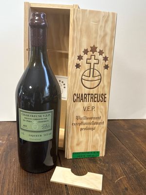 une bouteille de vin à côté d'une caisse en bois sur une table
